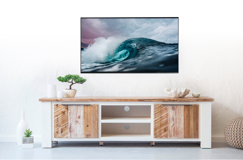 Beach house inspired interior showing wood and white washed wood TV stand with TV mounted to white wall